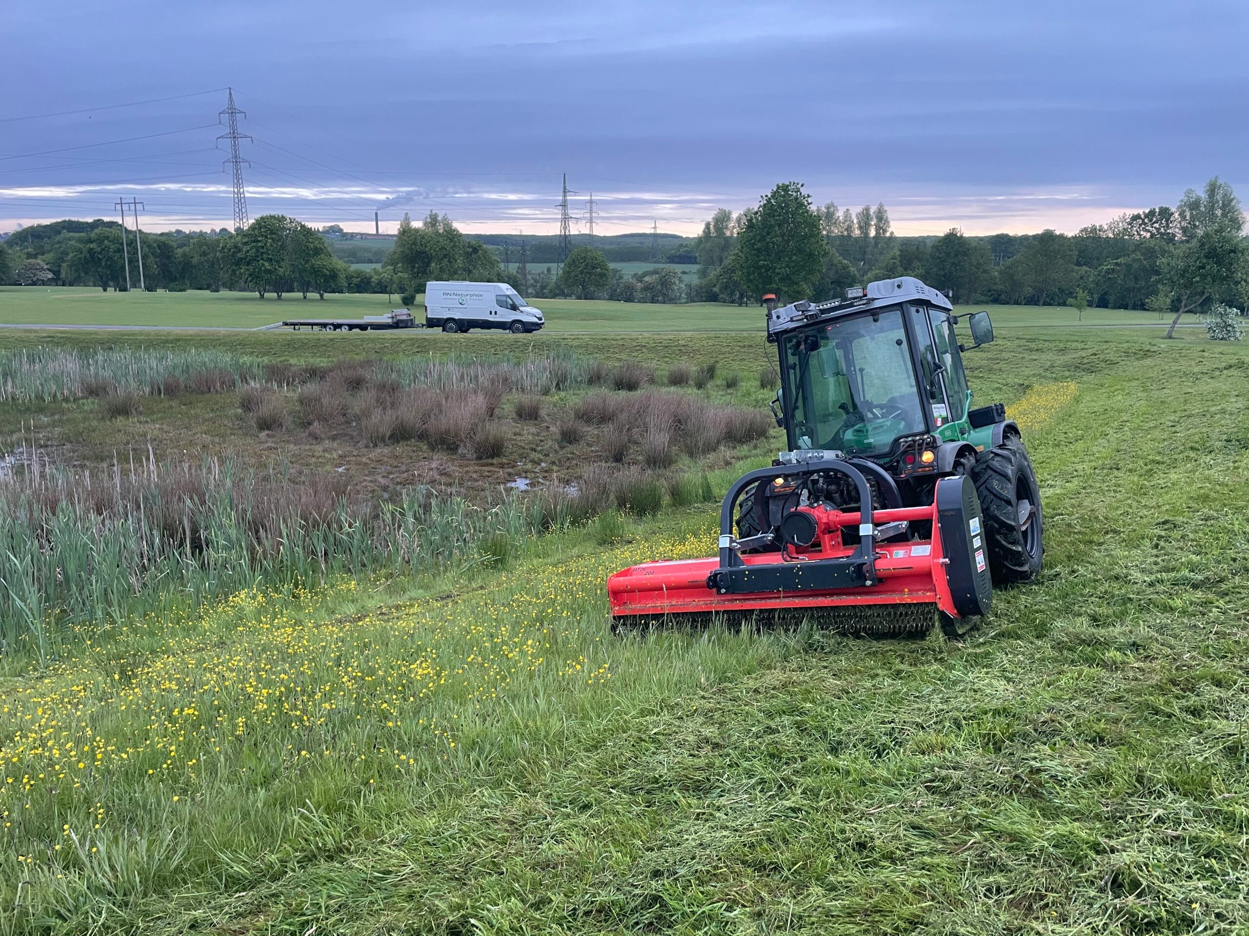 Traktor laver Brakpudsning og klipper græs ved marken